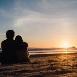 Two lovers and a beachcomber by the real sea